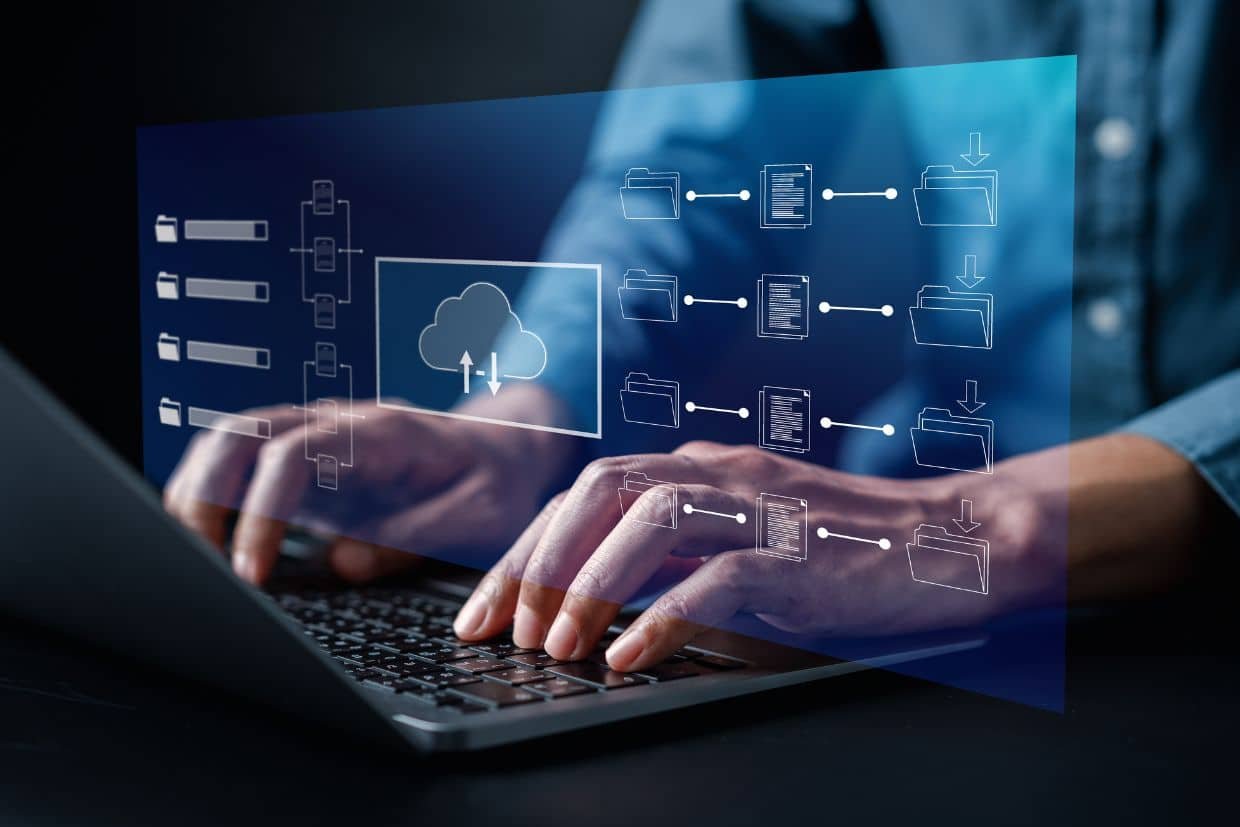 Close-up of hands typing on a laptop keyboard with a digital overlay of cloud computing and file management icons, representing cloud storage, data synchronization, and digital workflow automation."
Let me know if you need any modifications!